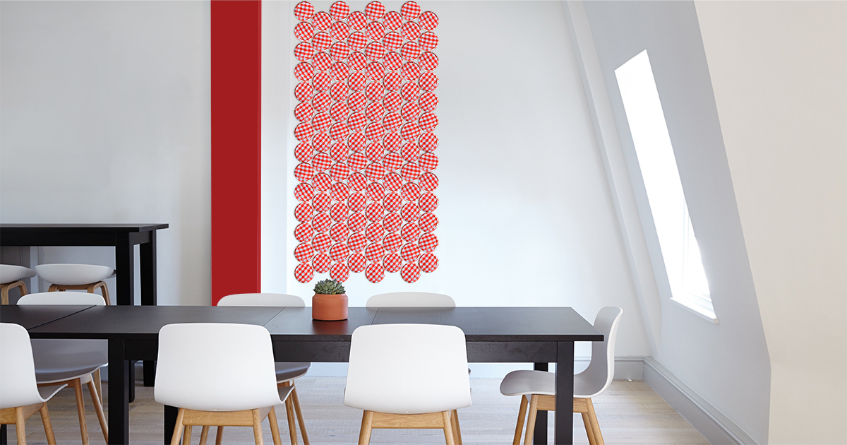 Photo d'une salle à manger où le mur principal et décoré avec des couvercles de pot de confiture à carreaux rouges et blancs. Le recyclage et le design font bon ménage. On voit ici un bel exemple pour ajouter un accent de rouge à une salle à manger, tout en redonnant une seconde vie à un objet.